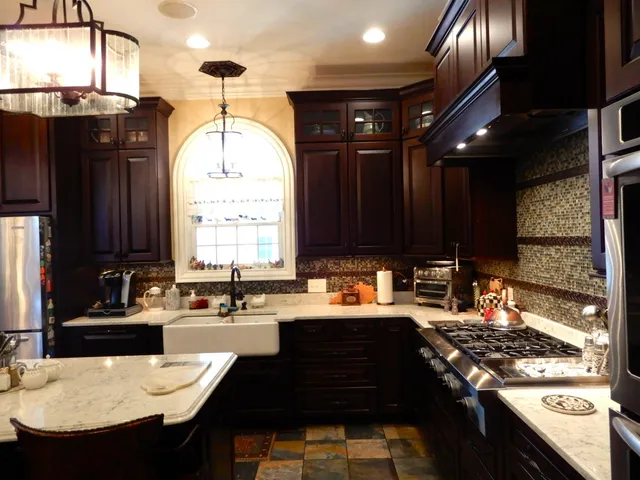 a kitchen with stainless steel appliances granite countertop a sink a stove and a refrigerator