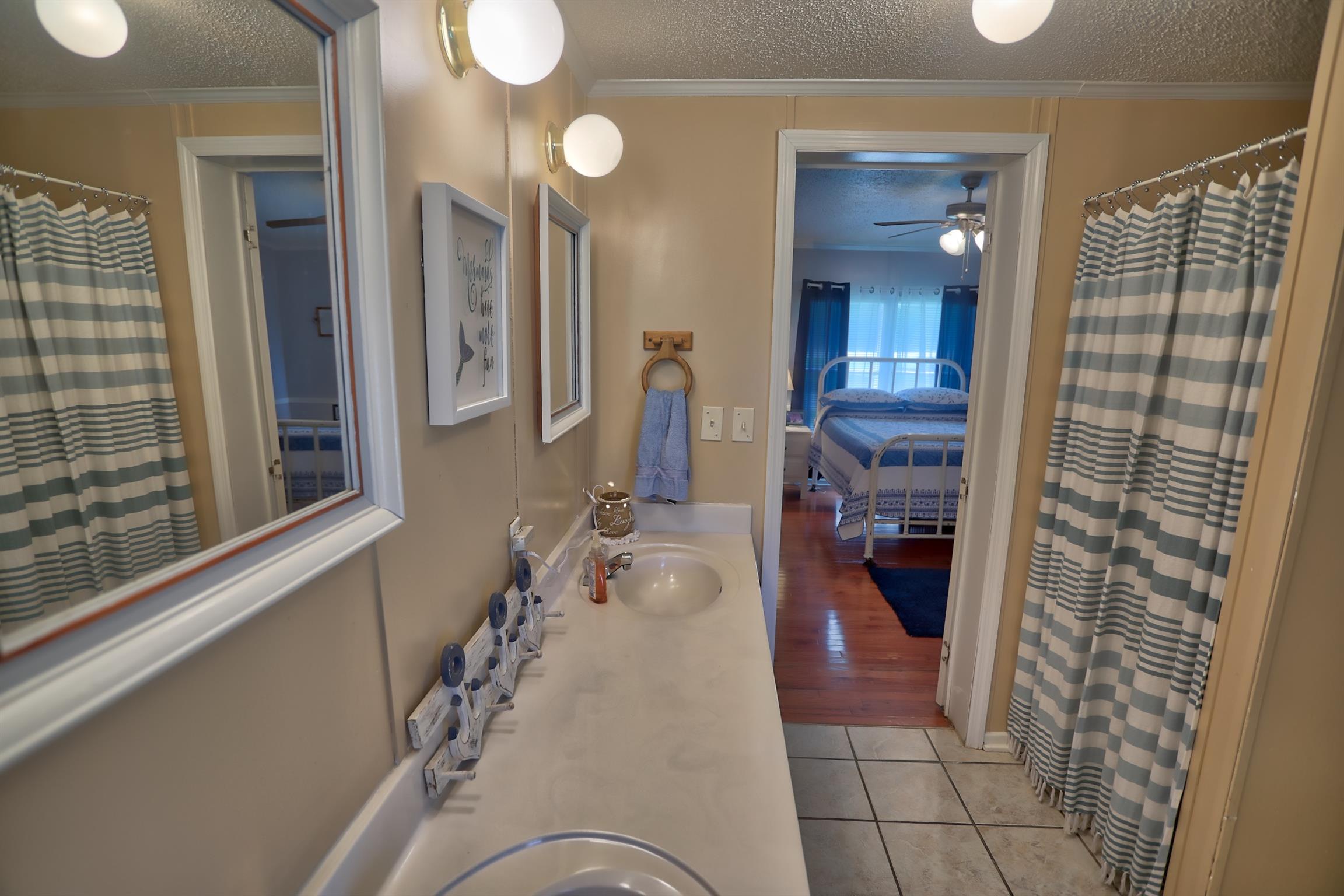 952 North Corinth Road Portland, TN 37148 - Photo 15 of 25 a en suite bathroom with a sink and mirror with bathtub
