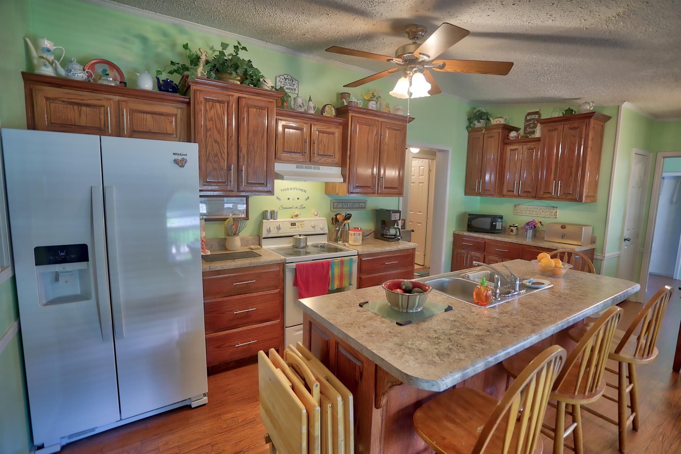 952 North Corinth Road Portland, TN 37148 - Photo 6 of 25 a kitchen with granite countertop a refrigerator a stove a sink dishwasher and wooden cabinets with wooden floor