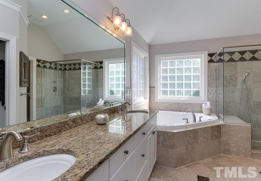 936 Oak Creek Road Raleigh, NC 27615 - Photo 16 of 25 a bathroom with double vanity sinks double vanity shower and a bathtub