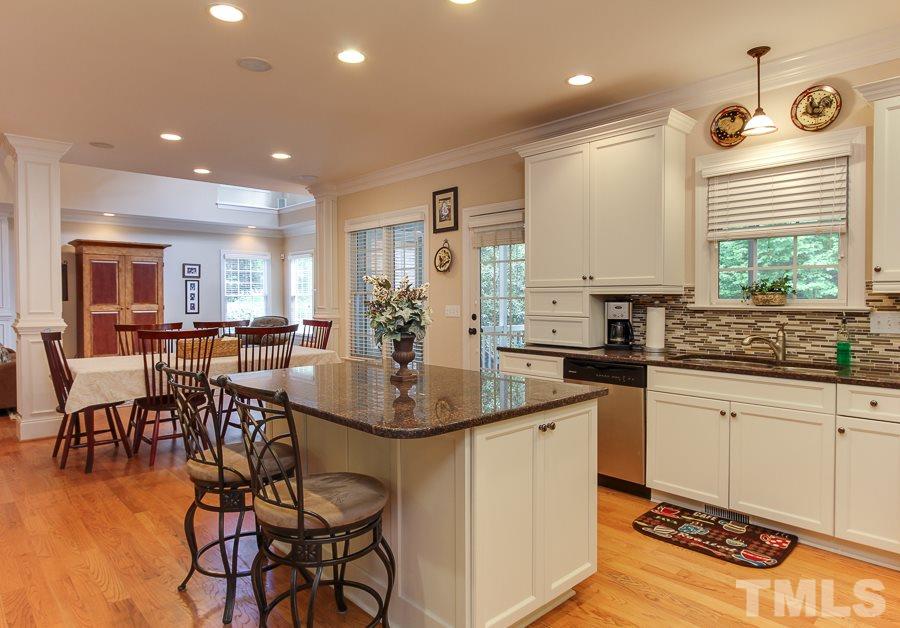 936 Oak Creek Road Raleigh, NC 27615 - Photo 6 of 25 a kitchen with center island table and chairs in it