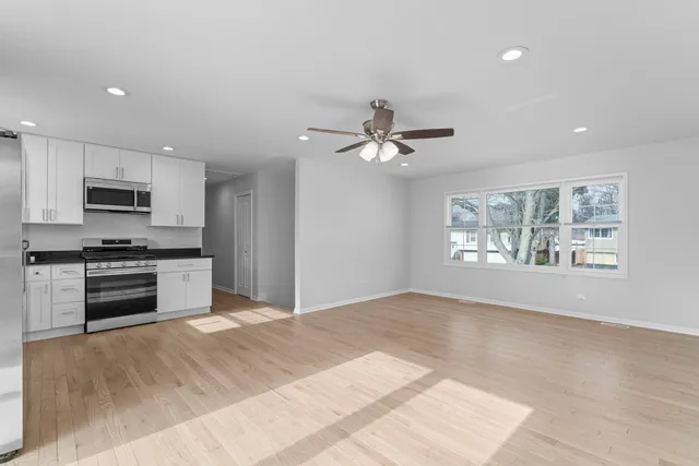 a kitchen with granite countertop a stove cabinets and microwave