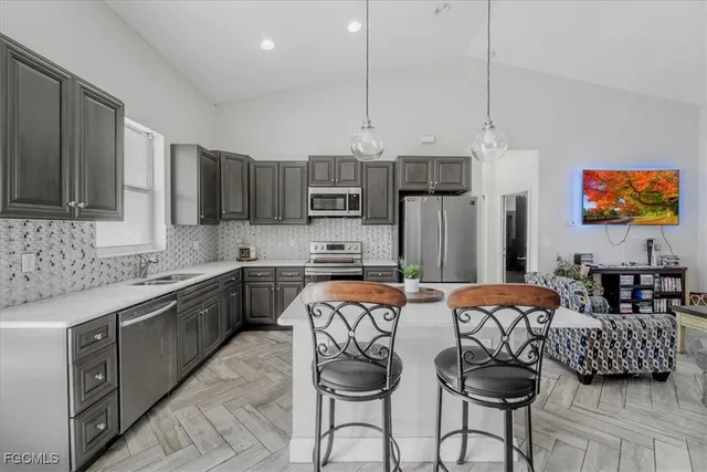 a kitchen with a sink a stove a refrigerator a center island and cabinets