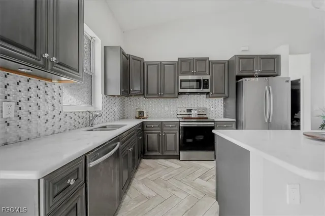 a kitchen with cabinets stainless steel appliances and wooden floor