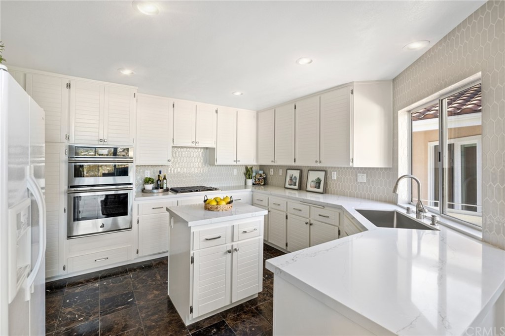 24955 Seagate Drive Dana Point, CA 92629 - Photo 6 of 39 a kitchen with a sink a stove a refrigerator and white cabinets