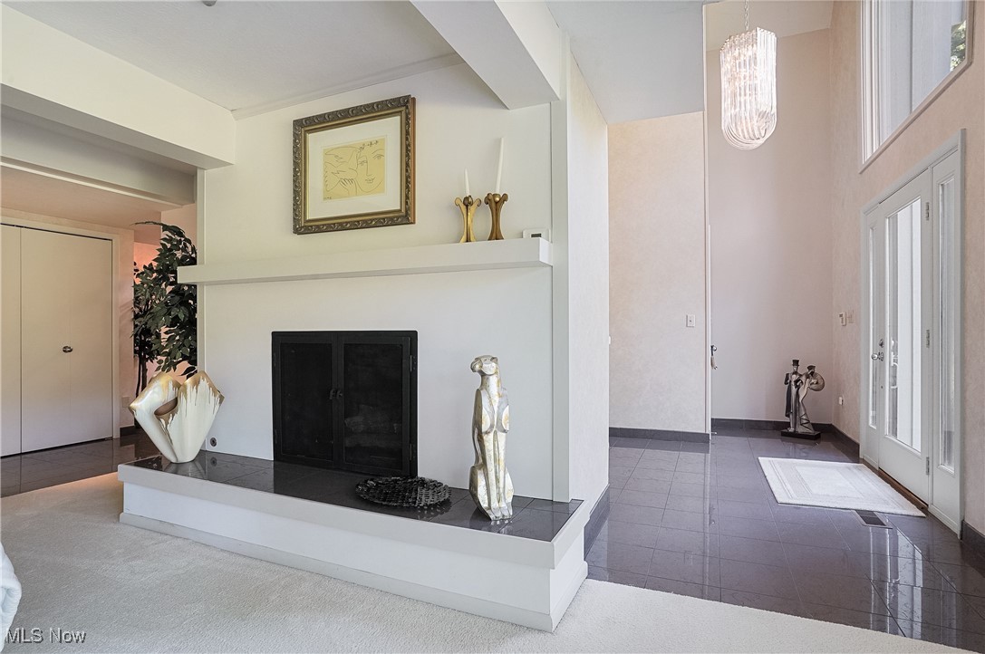 Living room with plenty of natural light, a notable chandelier, and carpet