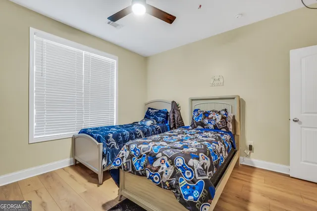 a bedroom with two beds and wooden floor