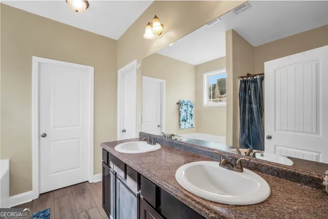 a bathroom with a granite countertop sink and a bathtub