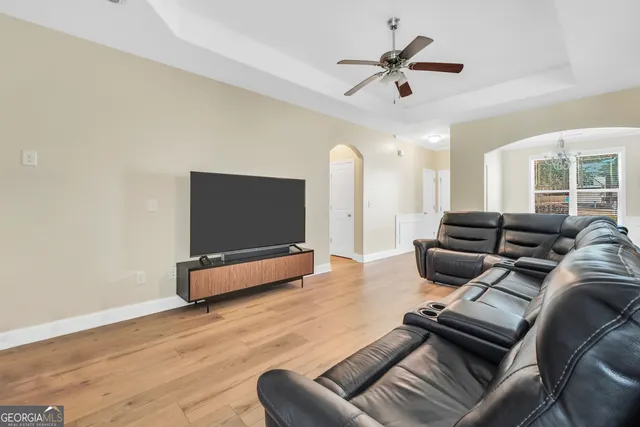 a living room with furniture a ceiling fan and a rug