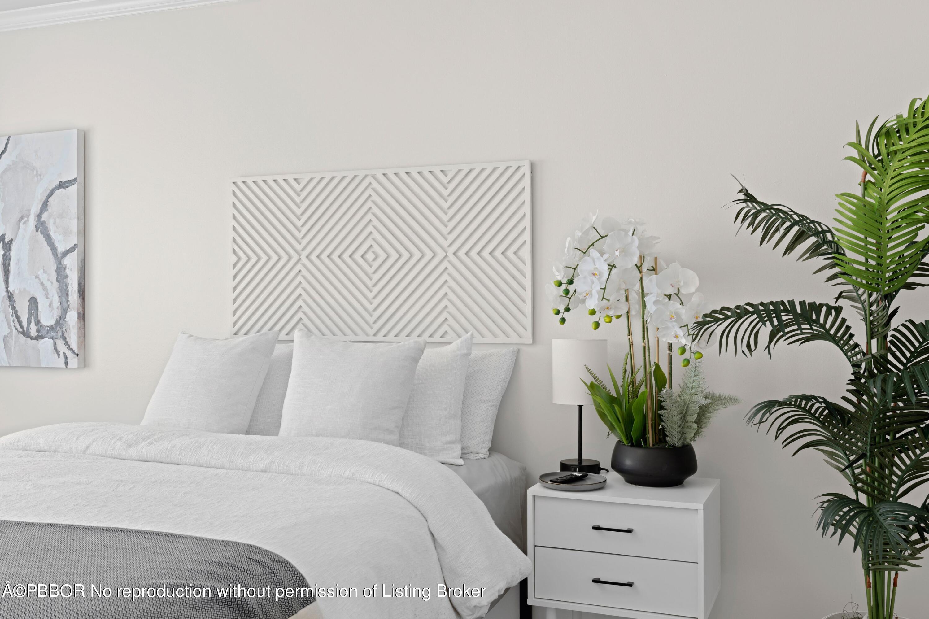 2195 Ibis Isle Road, Unit 1 Palm Beach, FL 33480 - Photo 12 of 38 a bedroom with a white bed and a potted plant
