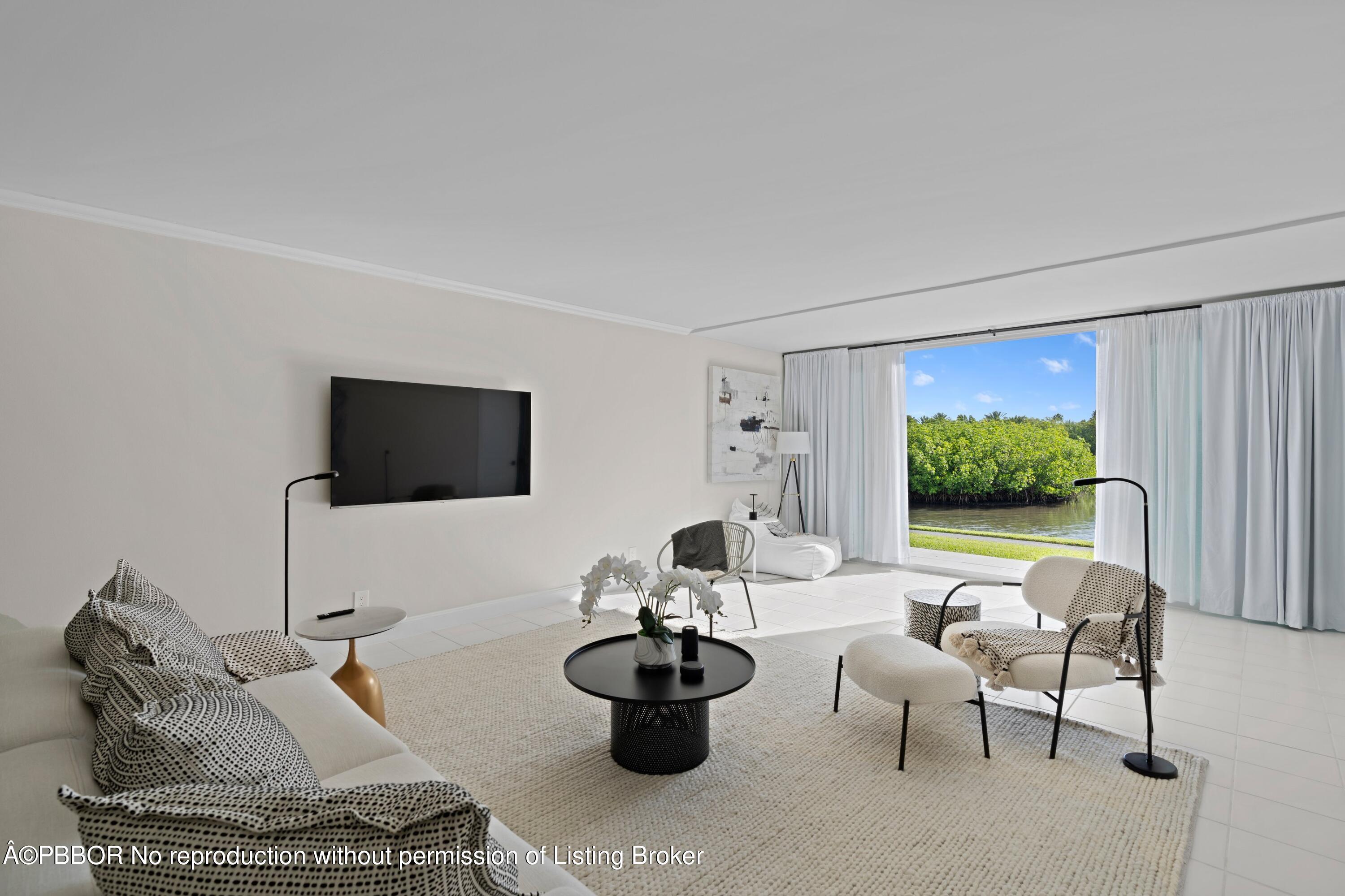 2195 Ibis Isle Road, Unit 1 Palm Beach, FL 33480 - Photo 2 of 38 a living room with furniture and a flat screen tv