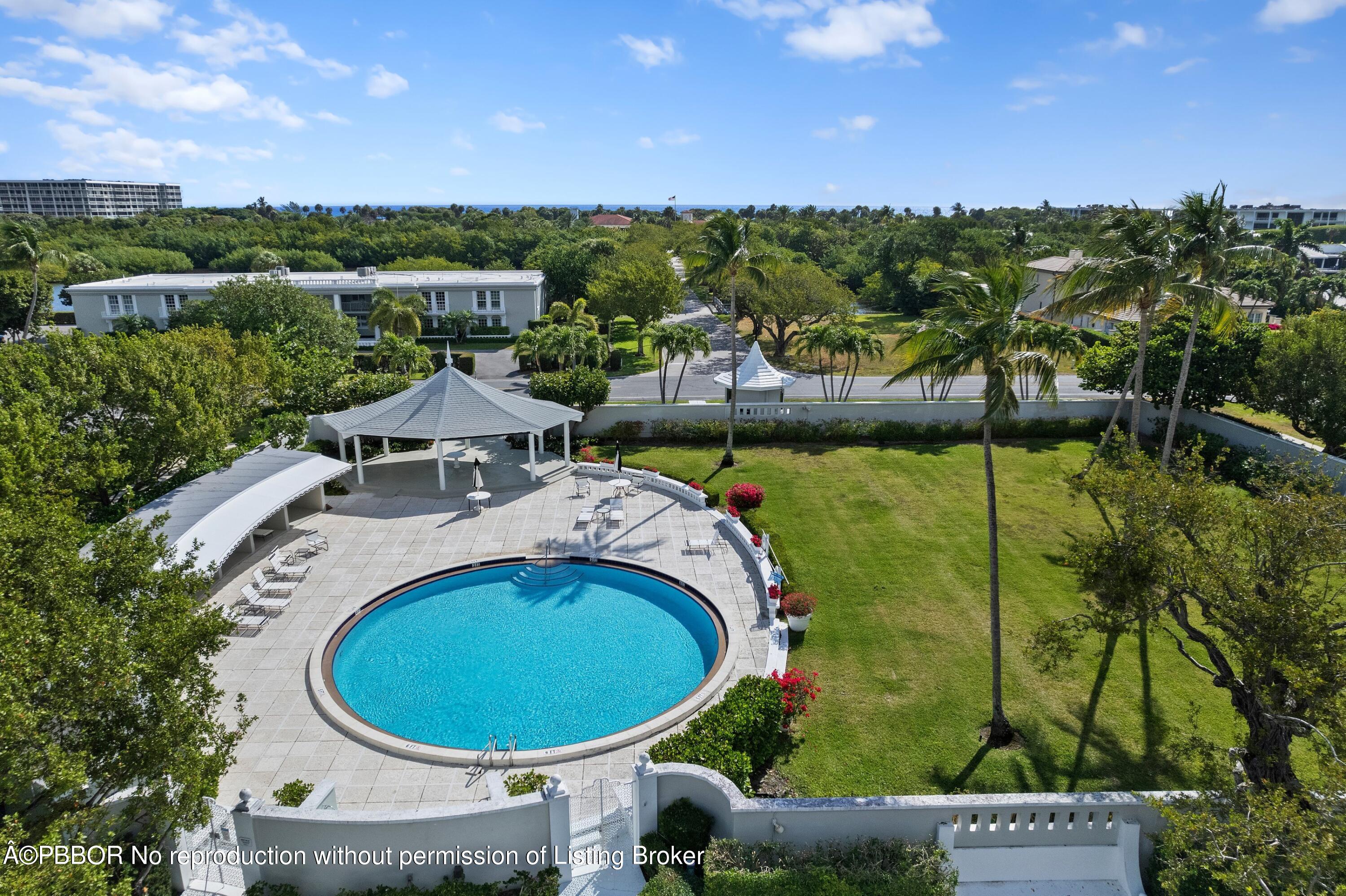 2195 Ibis Isle Road, Unit 1 Palm Beach, FL 33480 - Photo 30 of 38 a view of a swimming pool with lawn chairs under an umbrella