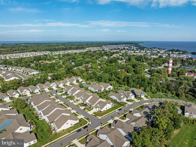 a living room with a floor to ceiling window and kitchen view
