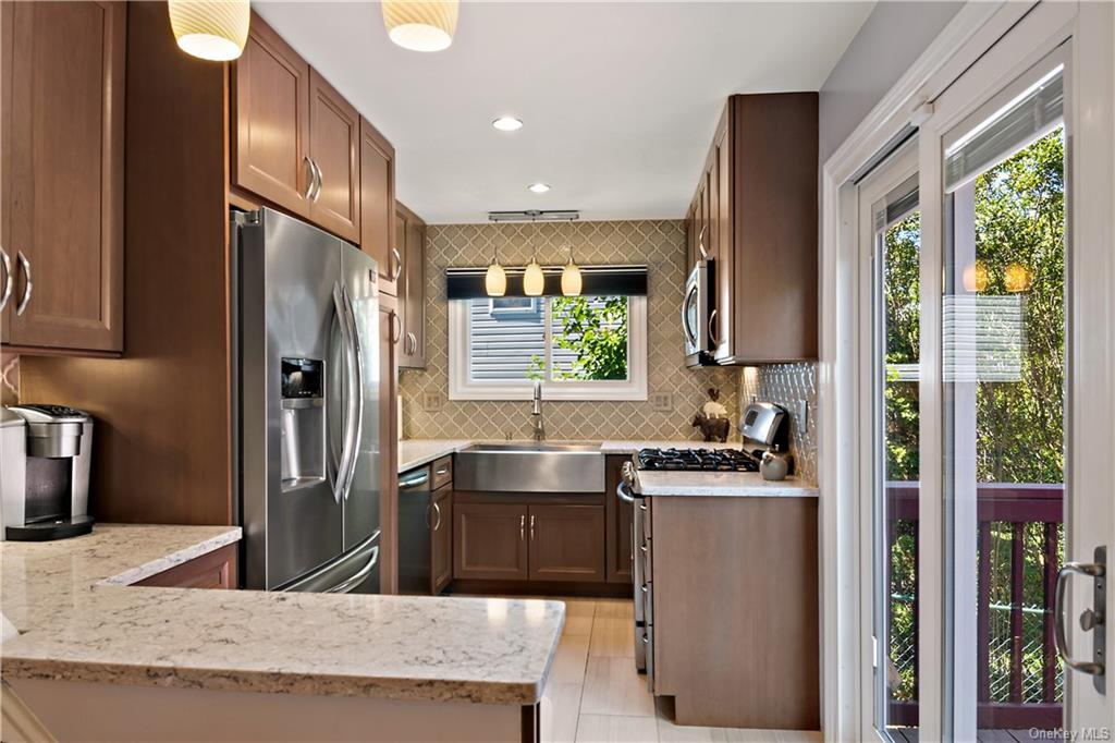 a kitchen with stainless steel appliances granite countertop a refrigerator a sink a stove and a refrigerator