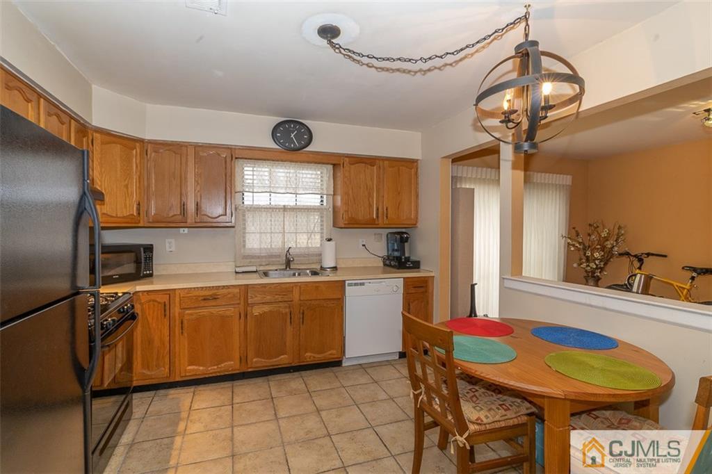 605 Timber Oaks Road, Unit 605 Edison, NJ 08820 - Photo 8 of 22 a kitchen with a sink a stove cabinets and dining table chair