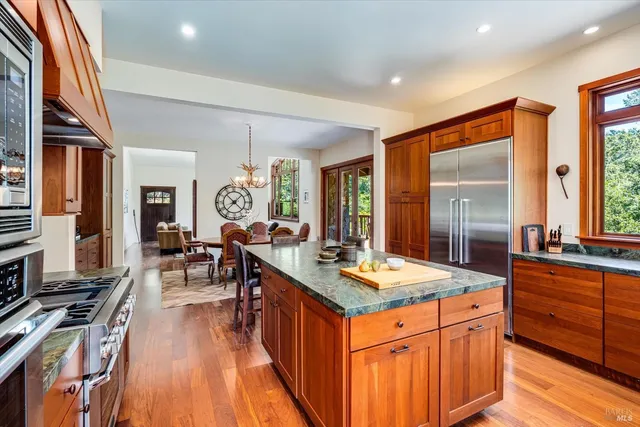 a kitchen with stainless steel appliances granite countertop sink stove top oven and cabinets