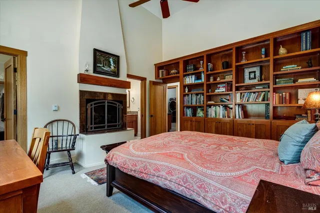 a bedroom with a bed a book shelf and a shelf