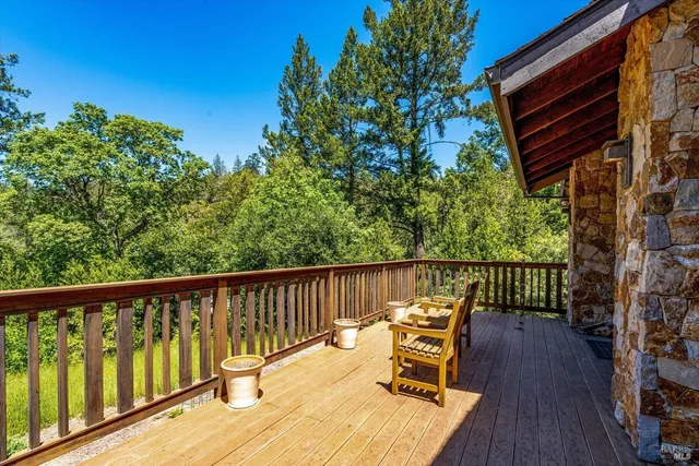 a view of a balcony with wooden floor and outdoor seating