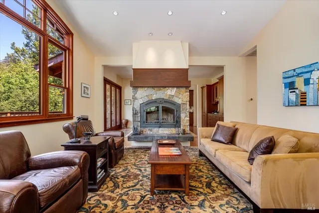 a living room with furniture fireplace and large window