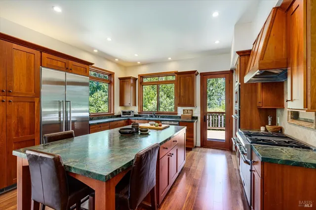 a kitchen with a stove a sink a counter space and living room filled with furniture
