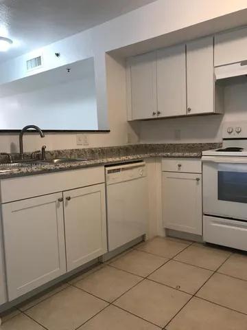 a kitchen with cabinets and white stainless steel appliances