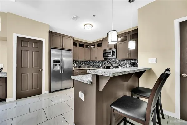 a kitchen with kitchen island a sink stove and refrigerator