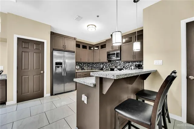 a kitchen with kitchen island a sink stove and refrigerator