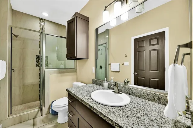 a bathroom with a granite countertop sink toilet and shower