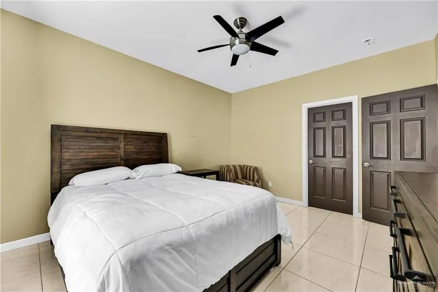 a bedroom with a large bed and a ceiling fan