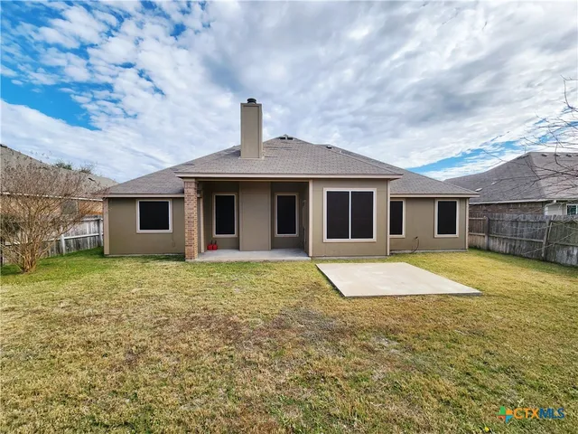 a view of a yard with wooden fence