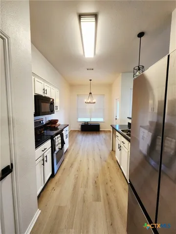 a kitchen with stainless steel appliances a refrigerator stove and microwave