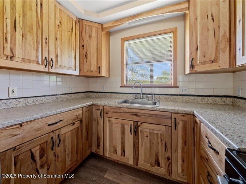9-17 Vago Road Tunkhannock, PA 18657 - Photo 16 of 57 a kitchen with stainless steel appliances granite countertop a sink and cabinets with wooden floor