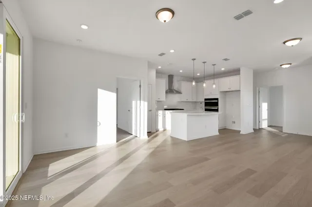 a view of kitchen with stainless steel appliances refrigerator oven and cabinets