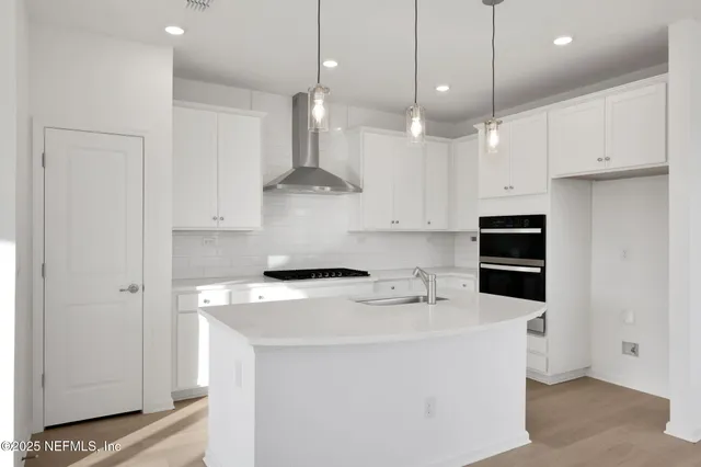 a kitchen with kitchen island a stove a sink a center island and a refrigerator