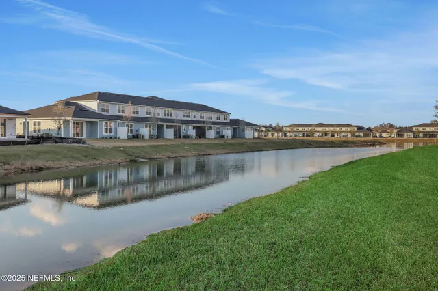 a view of a house with a yard and a pond