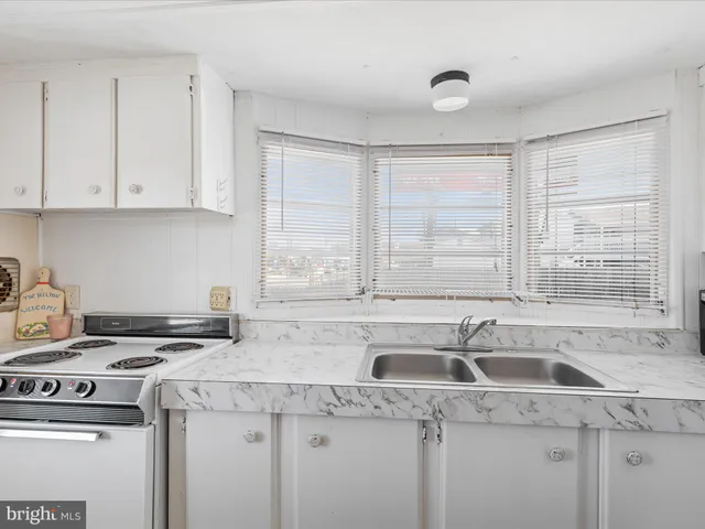a kitchen with a sink stove top oven and cabinets
