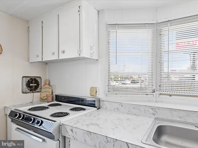 a kitchen with granite countertop a stove and a sink