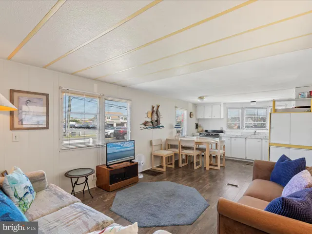 a living room with furniture and kitchen view