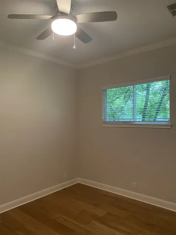 a view of a room that has wooden floor and large window