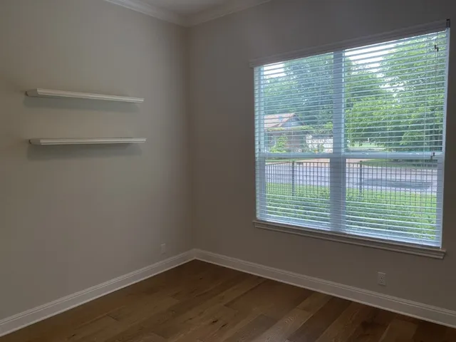 a view of a small space with wooden floor and a window