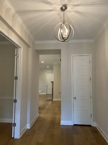 a view of a room with chandelier fan and kitchen view