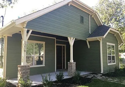 a front view of a house with a garden