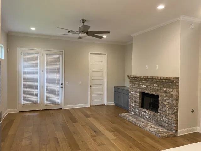 an empty room with a fireplace and wooden floor
