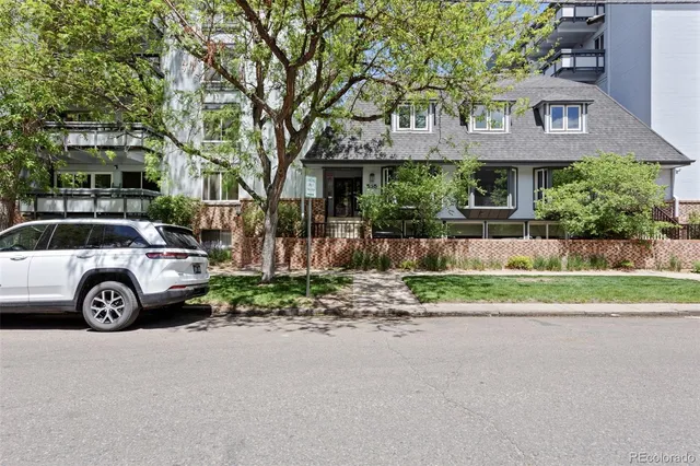 a view of a car parked in front of a brick house