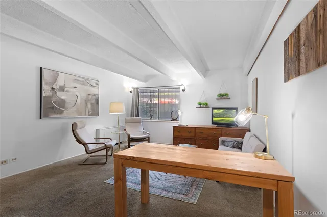 a living room with furniture a rug and a painting on the wall