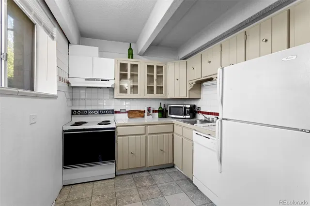 a kitchen with stainless steel appliances granite countertop a refrigerator sink and white cabinets