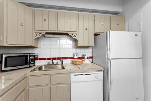 a kitchen with refrigerator and cabinets