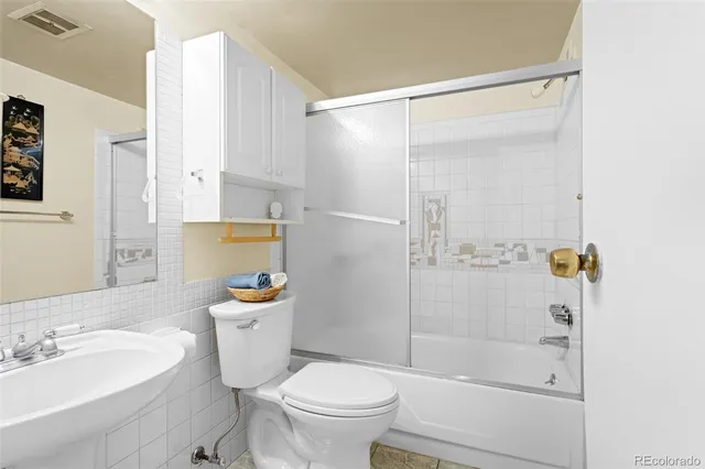 a bathroom with a sink mirror toilet and shower