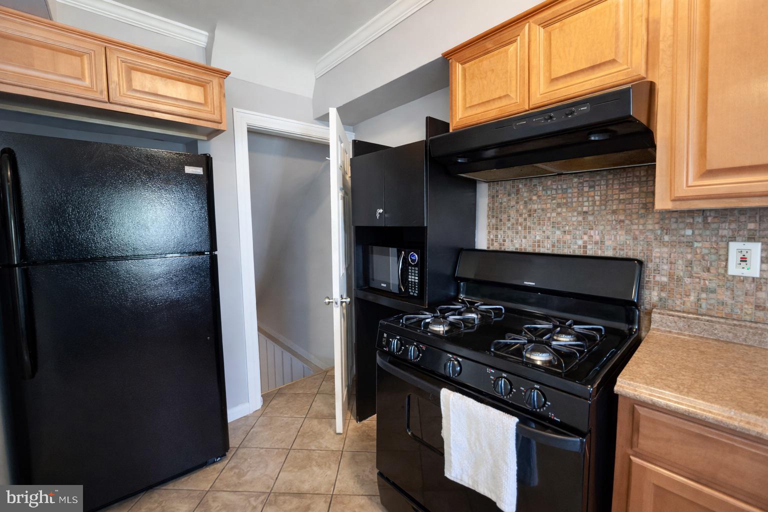 3325 McShane Way Baltimore, MD 21222 - Photo 11 of 23 a kitchen with a stove and a refrigerator