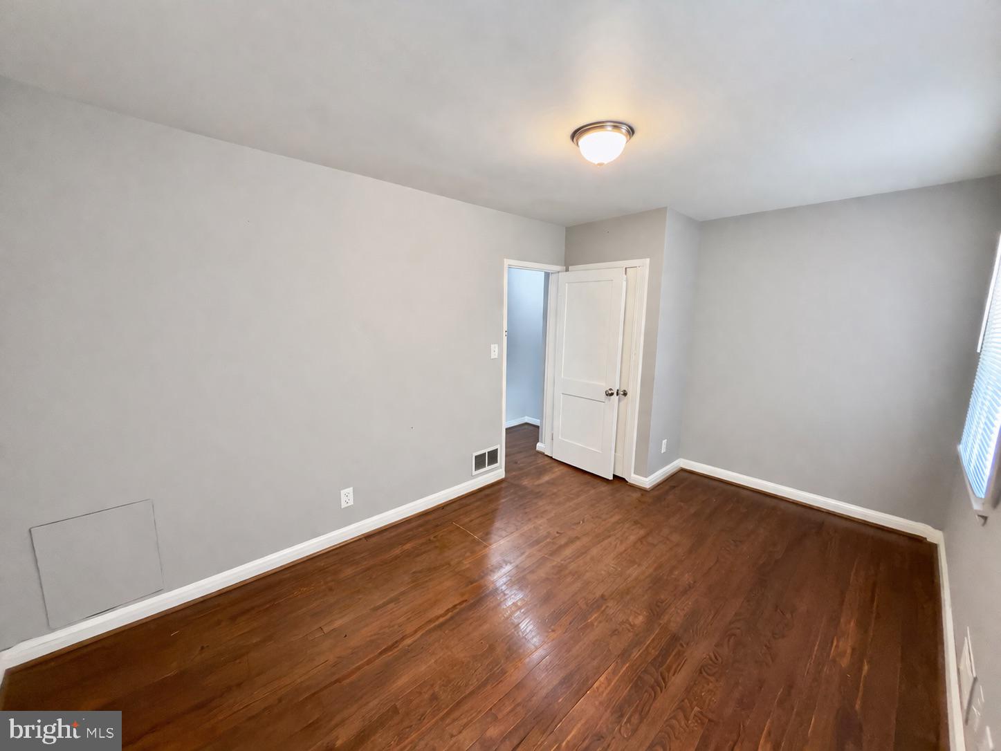 3325 McShane Way Baltimore, MD 21222 - Photo 16 of 23 a view of an empty room with wooden floor and a window